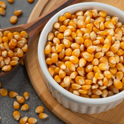 Bowl with corn kernels for popcorn. Detail of wooden spoon and bamboo support.